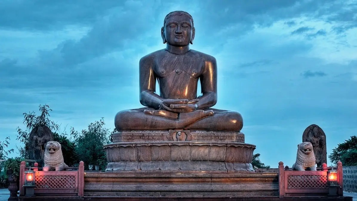 Lord Mahavir meditating statue at Jain temple with serene sky